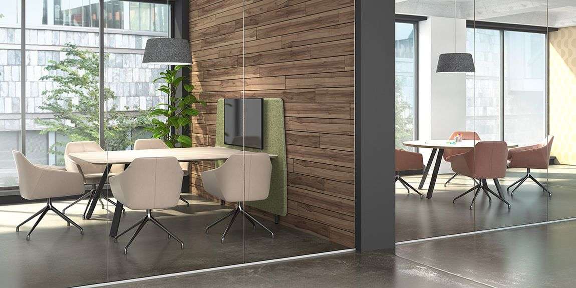 Round conference table and square conference table in an office space with ergonomic seating and natural light